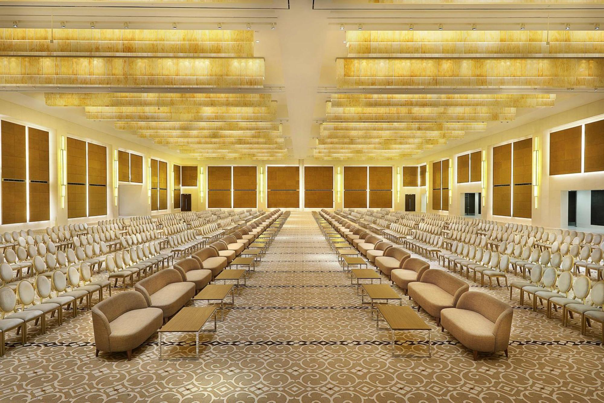 Hilton Riyadh Hotel & Residences Kültér fotó The photo shows a spacious, elegantly designed hall with a luxurious atmosphere. The room features two rows of beige sofas lined up along the sides, with a central aisle. The walls are adorned with large windows that allow natural light to fill the s